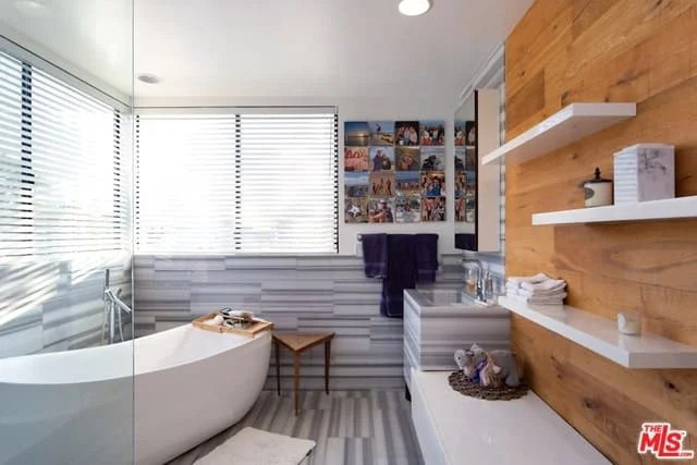 Statement bathtub surrounded by artwork for chic bathroom decor.