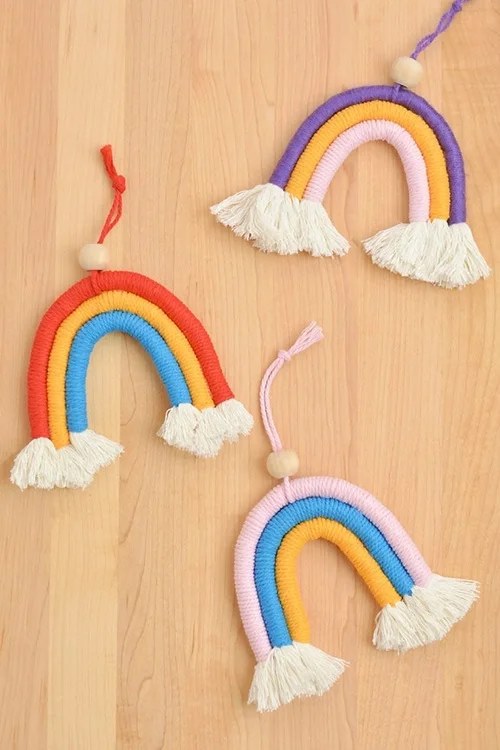 Colorful macrame rainbow wall hanging with yarn tassels.